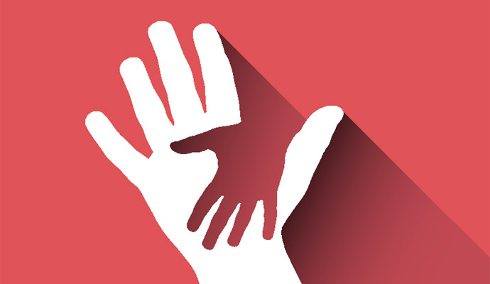 Two hands on a red background, one adult and one child. The adult's hand is white, and is holding the child's hand, which is red